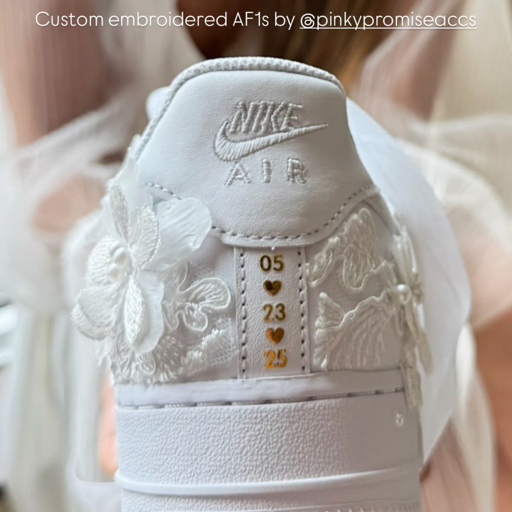 White sneaker with custom embroidery held by a person, text overlay about husband being a sneaker head.