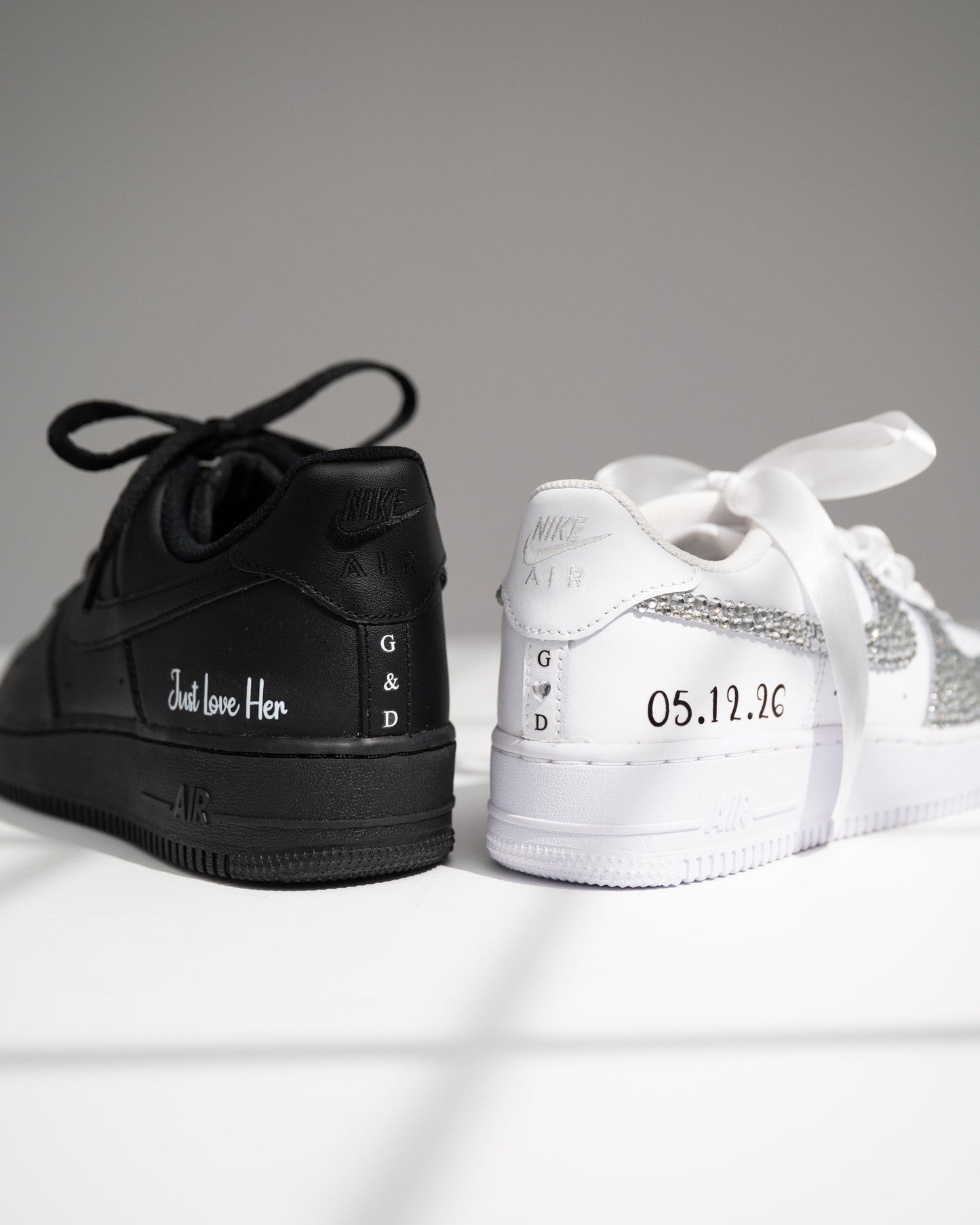 Black and white sneakers with personalized text on a light gray background