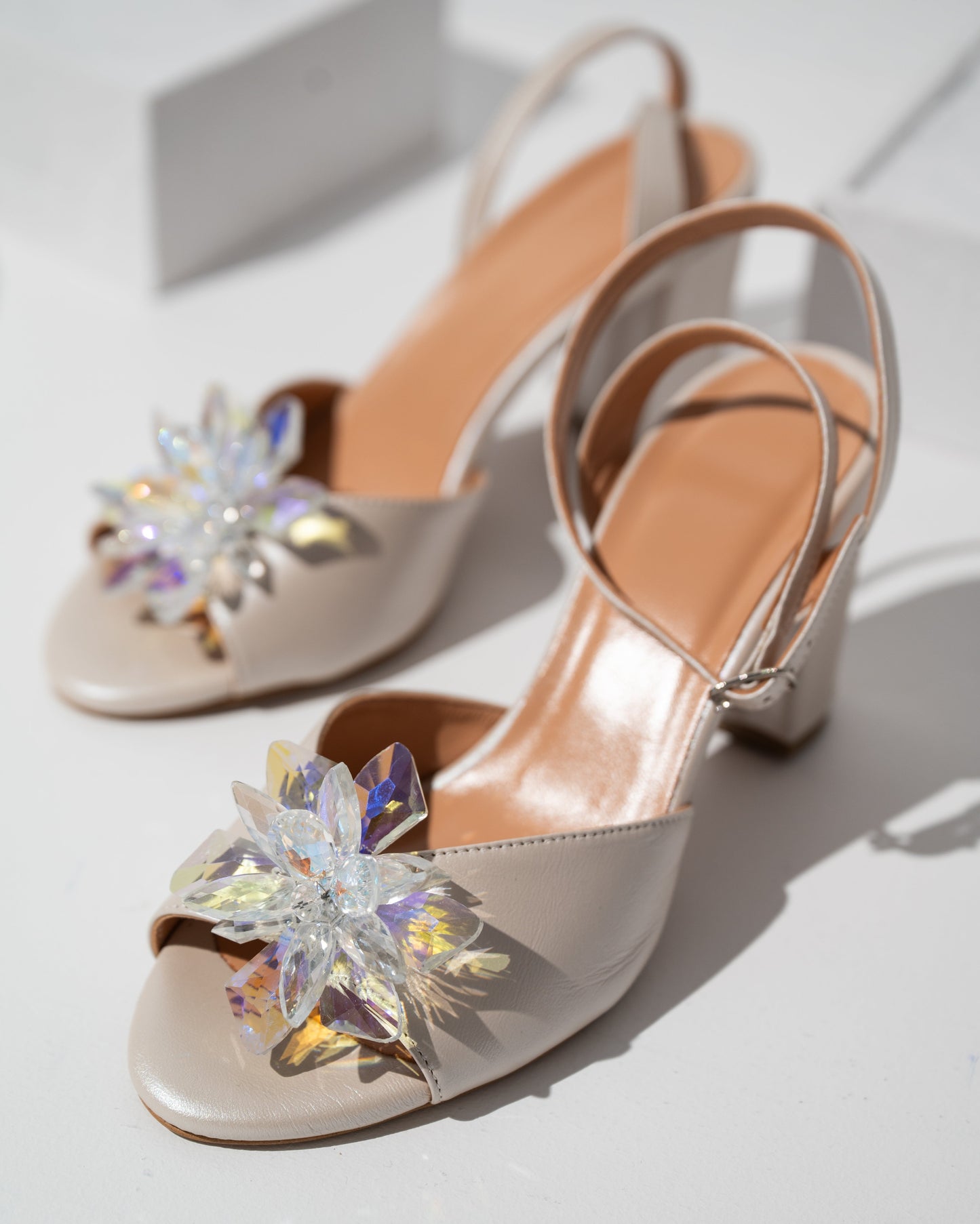 Ivory wedding shoes with decorative crystals on a light background