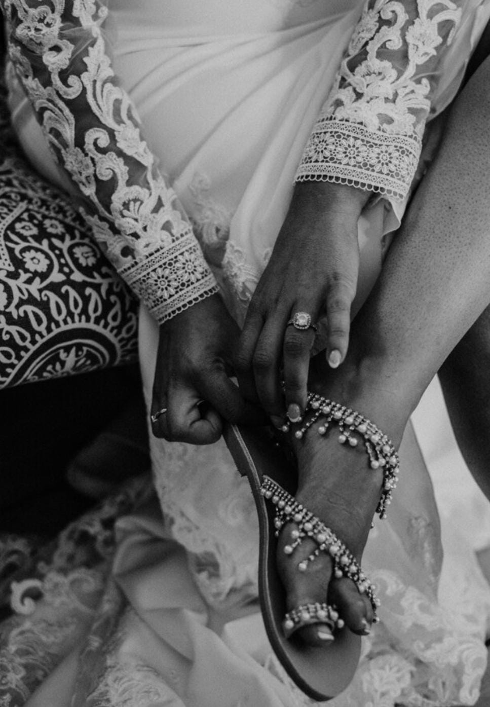 Person wearing a sandal with intricate beading, close-up shot.